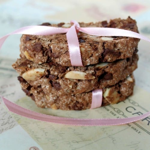 Three slices of brown chocolate biscotti, also with almonds, stacked and tied up with pink ribbon.