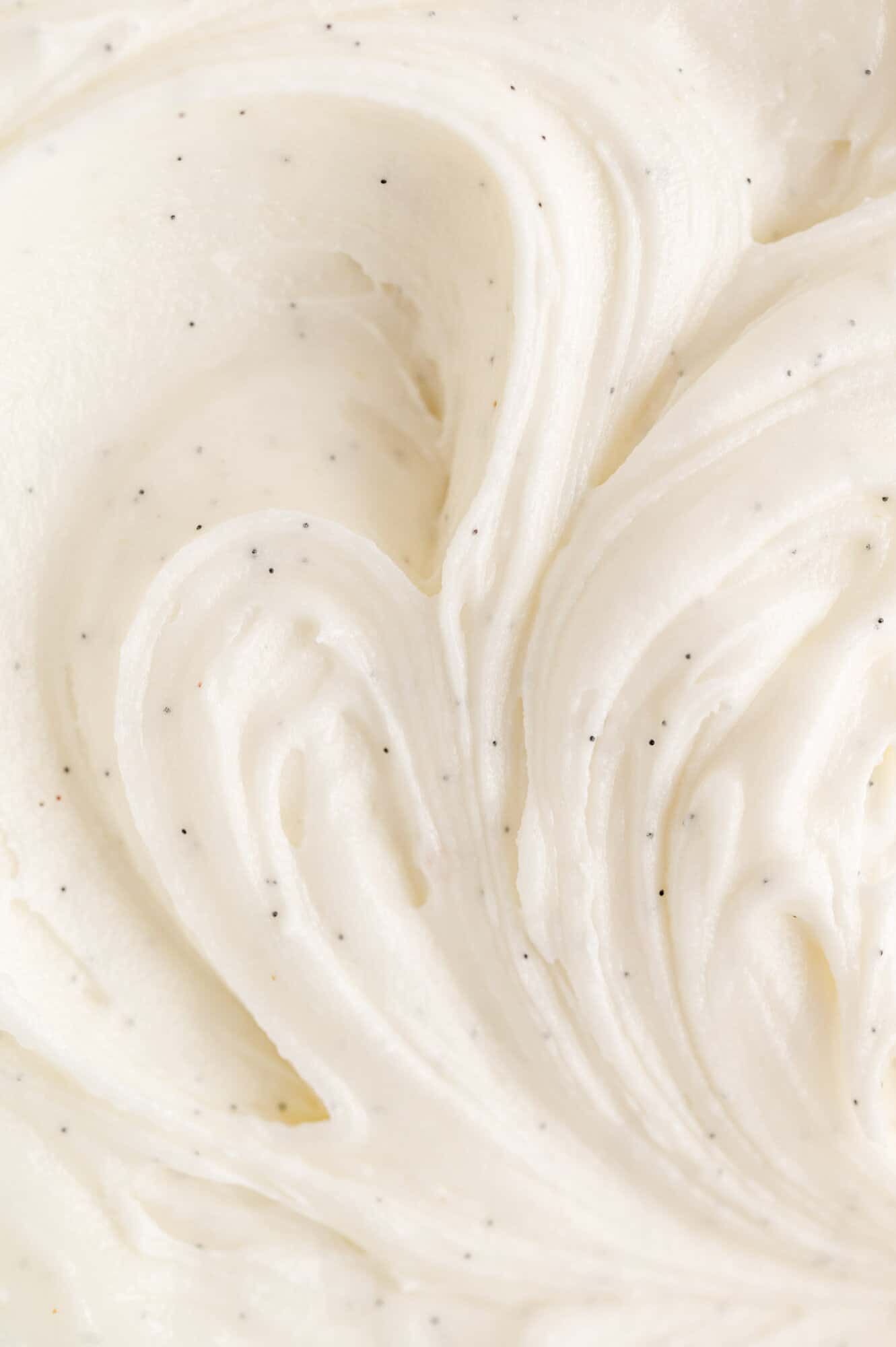 My favorite vanilla buttercream frosting that's rich, creamy, and made with real vanilla beans. Perfect for piping onto cakes and cupcakes! Close up of vanilla buttercream frosting with real vanilla seeds.
