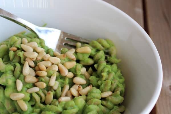 Partial closeup of pasta in white bowl with fork inserted.