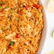 Overhead partial view of a large bowl of crockpot salsa chicken.