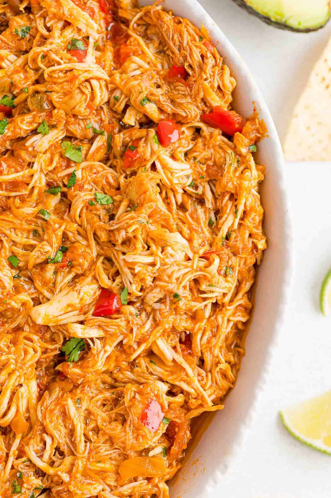 Overhead partial view of a large bowl of crockpot salsa chicken.