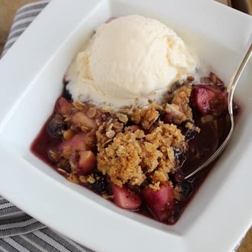 This apple blueberry crisp recipe is served in an adorable cast iron pan - it's the perfect dessert for any occasion and one of our absolute favorites!