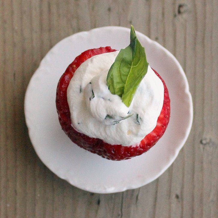 Overhead view of a strawberry stuffed with basil whipped cream