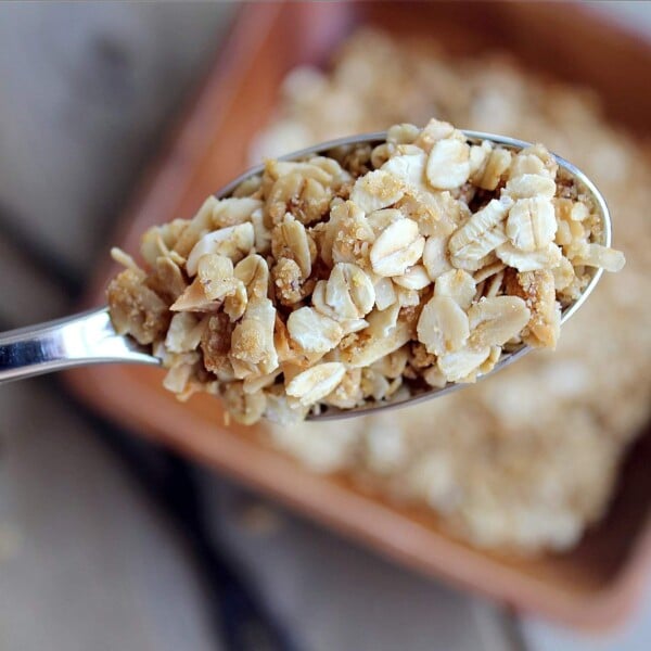 Overhead closeup of spoonful of granola, with bowl in background.