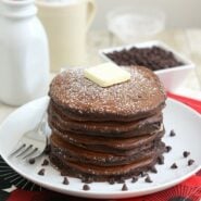 Stack of pancakes, garnished with pat of butter and mini chocolate chips.