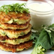 Stack of summer squash pancakes garnished with herbs.