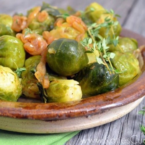Wooden bowl containing Brussels sprouts with smoked paprika and shallots.