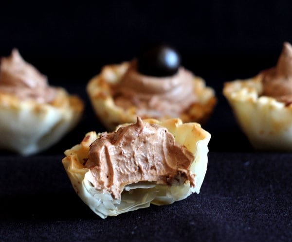Closeup of mousse cups, front center one is partially eaten, showing the inside of the cup.
