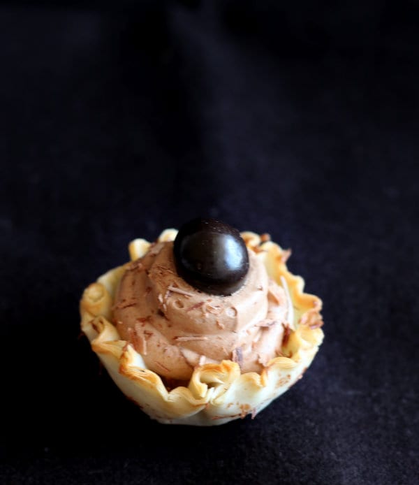 One mousse cup on a nearly black background. 