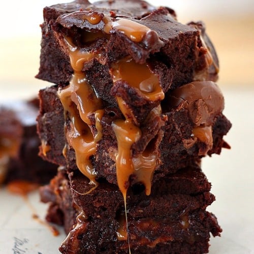 Front view of a stack of three caramel kissed brownies, with caramel dripping down. Text overlay reads "Caramel kisses brownies, Roxana home baking".