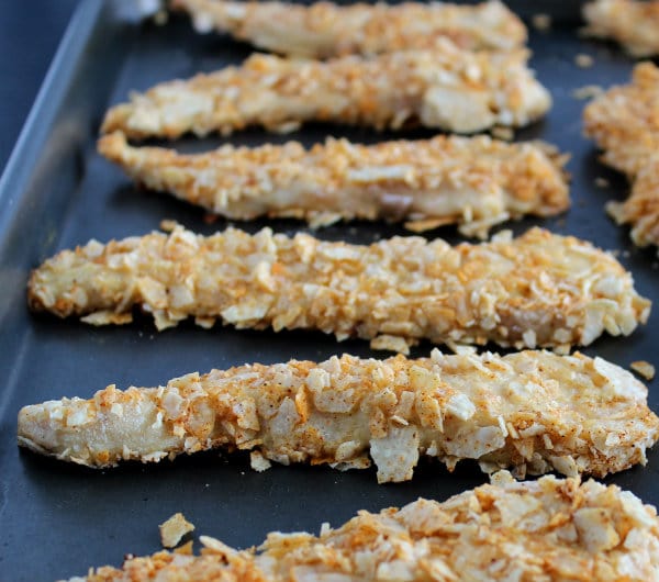 Front view of several chicken tenders in baking pan.