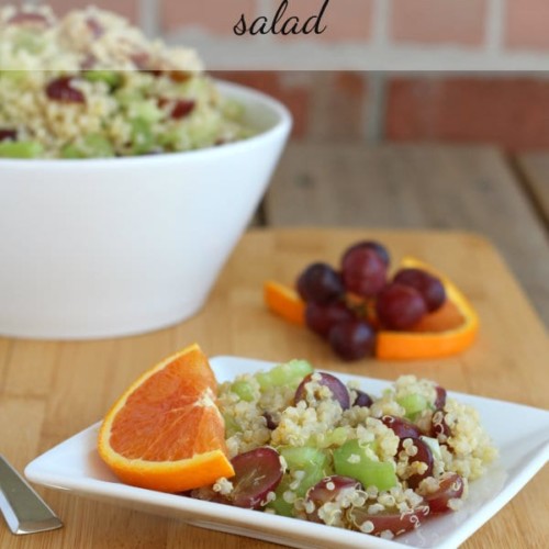 Quinoa salad on small square white plate garnished with half slice of orange.
