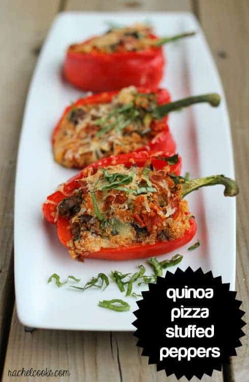 Image of three stuffed red bell peppers on a narrow white glass platter. An overlay reads "quinoa pizza stuffed peppers."