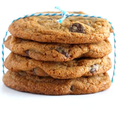 Stack of four chocolate chip cookies tied with blue and white string.