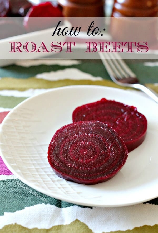 Two beet slices on round white plate, with fork and patterned fabric in background. Text overlay that reads "How to roast beets."