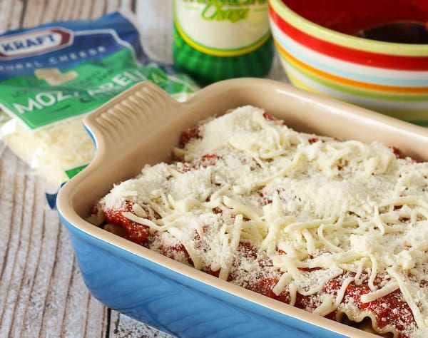 A baking dish full of lasagna rolls covered in mozzarella and parmesan cheese. 