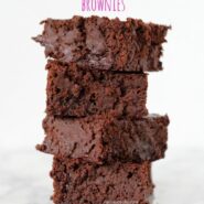 Four brownies stacked on white marble surface.