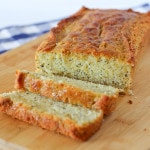 Image of a loaf of lemon poppy seed bread with two slices cut off.