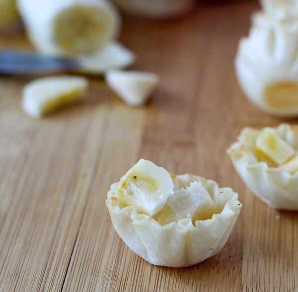 Pastry cups filled with sliced bananas.