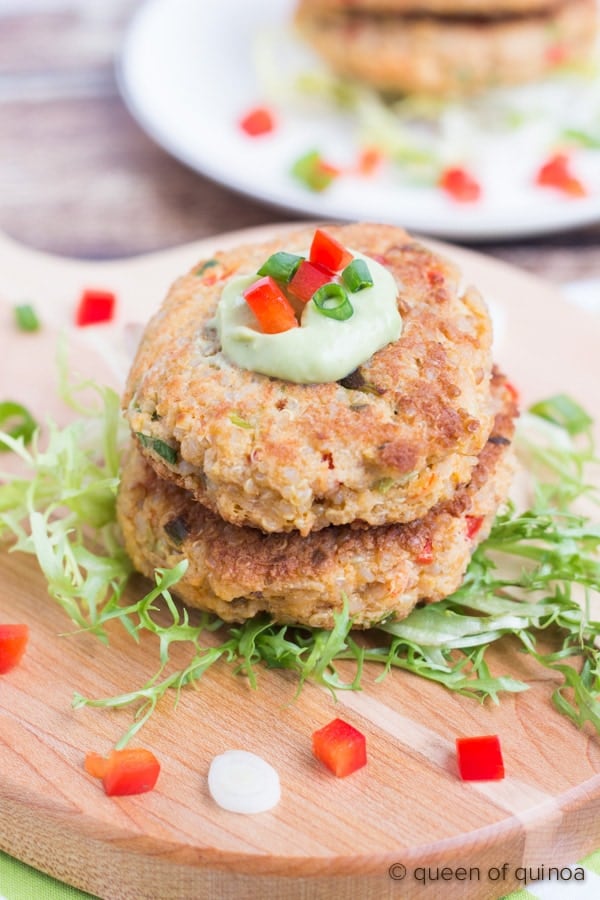 Two crab cakes stacked on each other with garnishes.