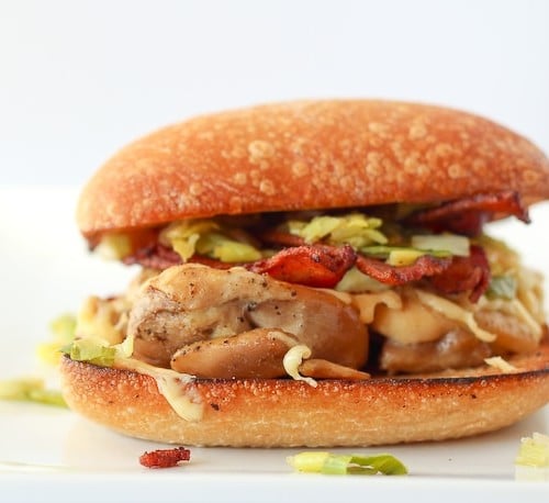 Chicken Burger with Bacon, Gouda and Leeks - close up image on a white background.