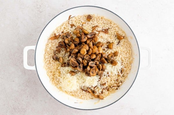 Roasted mushrooms and grated parmesan added to a skillet with the rest of the risotto.