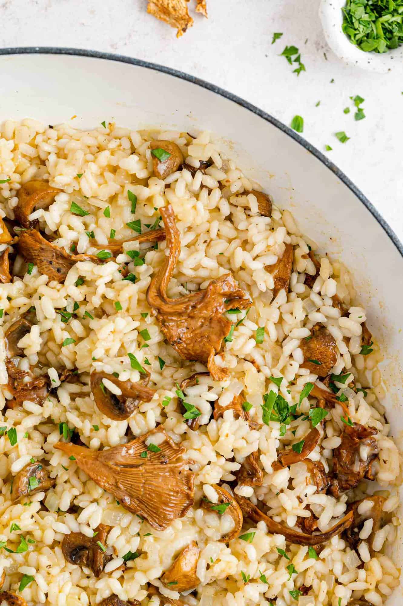 Close up of the corner of a skillet filled with mushroom risotto.