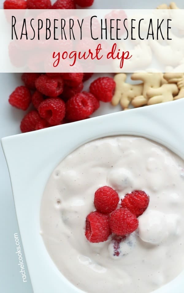 Overhead of square white dish containing dip, garnished with raspberries. Text overlay reads "Raspberry Cheesecake yogurt dip."