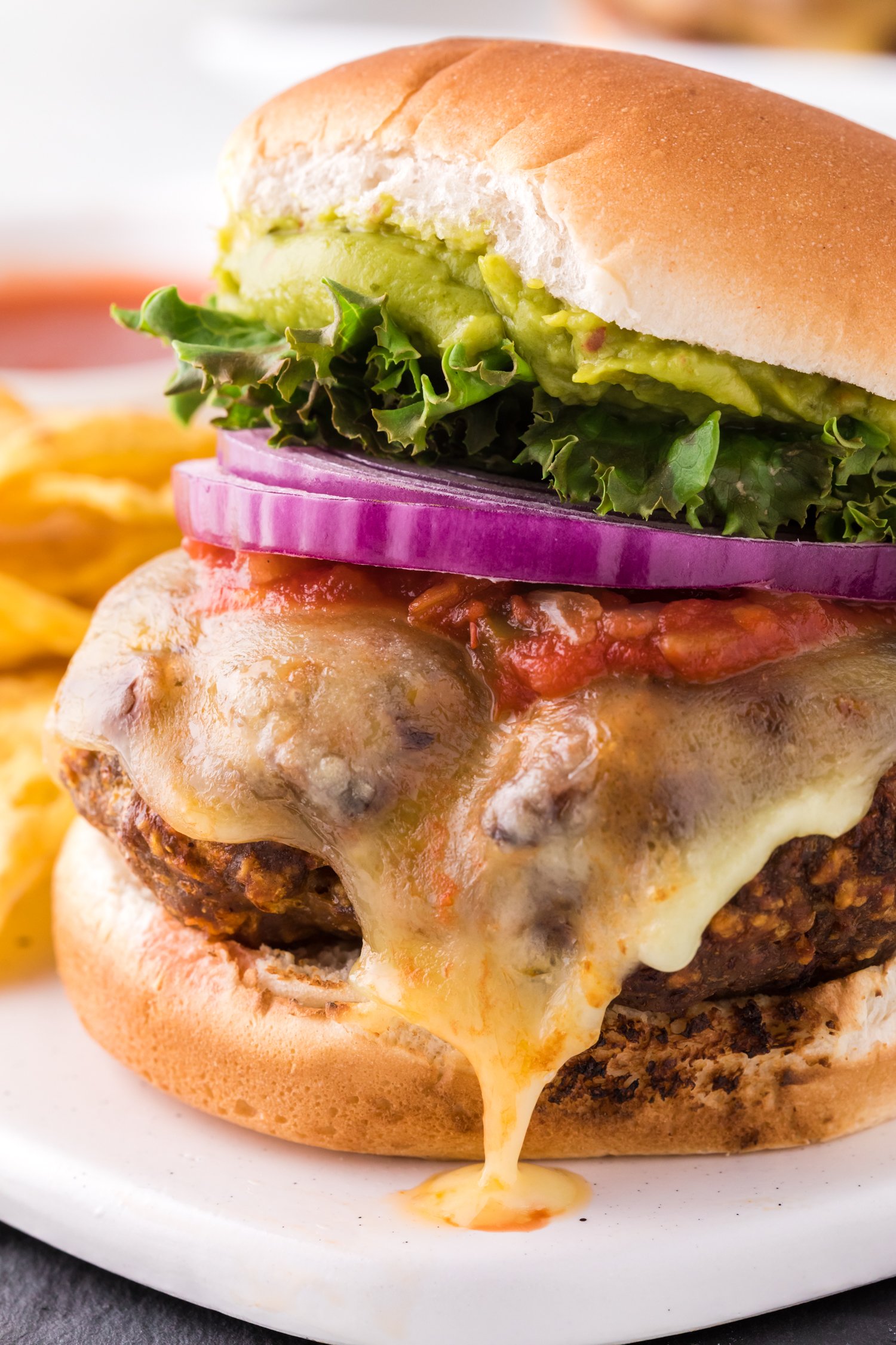 Close up of turkey burger with taco themed toppings.