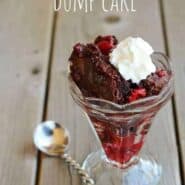A serving of dump cake in footed sundae bowl with whipped cream and fancy spoon. Text overlay reads "Black Forest Dump Cake."