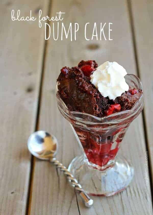 A serving of the cake in a footed sundae dish with a dab of whipped cream. Text overlay reads "black forest dump cake".