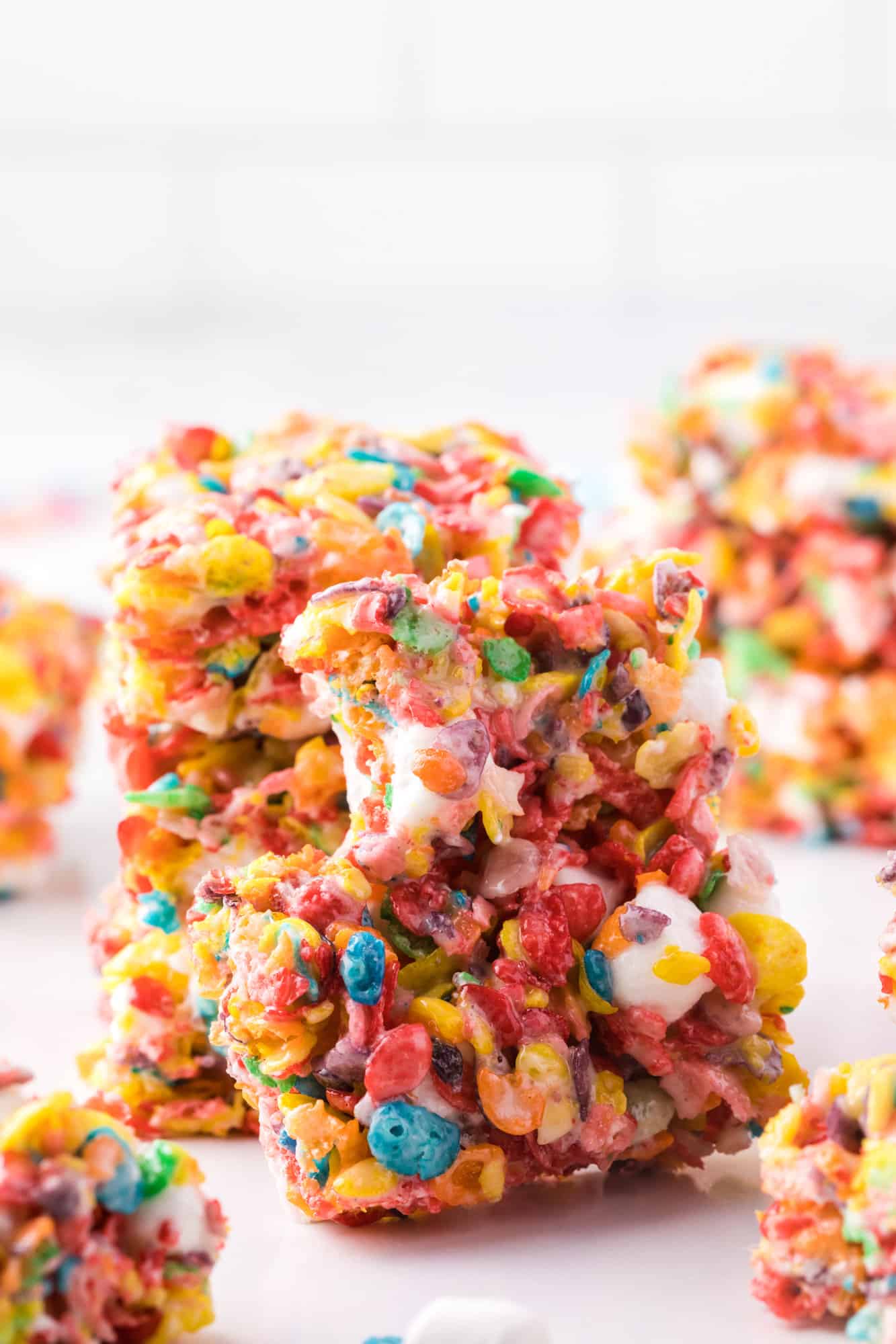 A stack of three Fruity Pebbles treats propping up a treat with a bite missing.