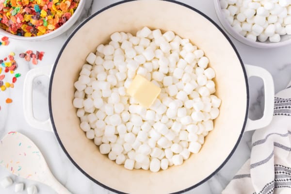 Butter added to a saucepan with mini marshmallows.