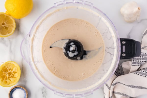 Blended tahini sauce in a food processor.