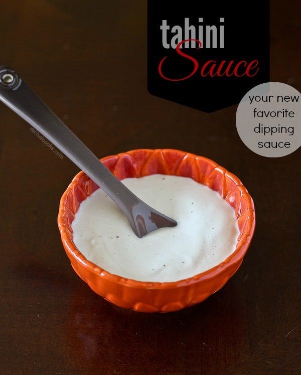 Small red bowl filled with tahini sauce with spoon inserted. Text overlay reads "Tahini Sauce, your new favorite dipping sauce."