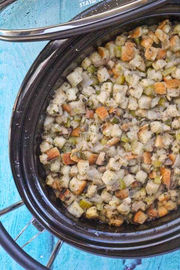 Partial overhead of stuffing in crockpot, with cover leaning against pot.