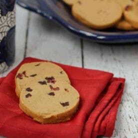 Front view of 2 gingerbread shortbread cookies on folded red napkin.