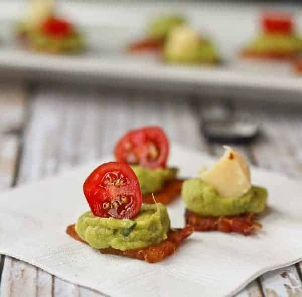 Bacon guacamole appetizers topped with half of cherry tomato or small piece of cheese.