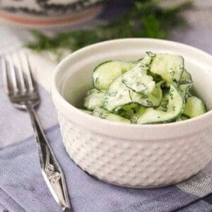 Small white serving bowl with cucumber salad.