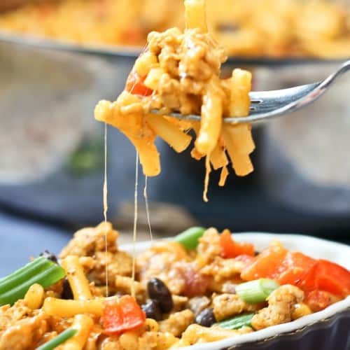 A forkful of mac and cheese held over a serving dish.