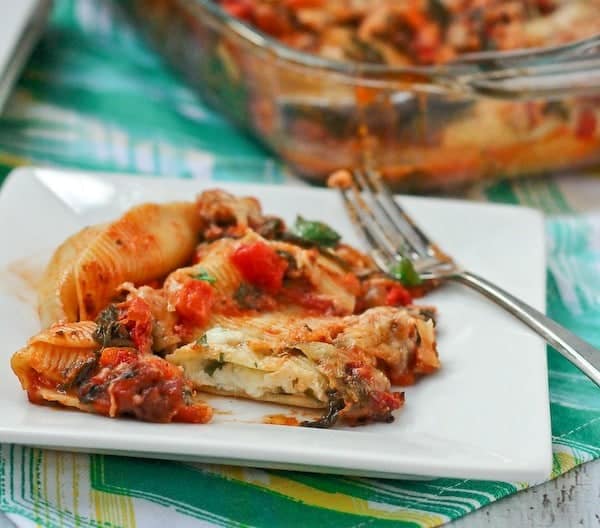 Front view of a serving of stuffed shells with one cut open.