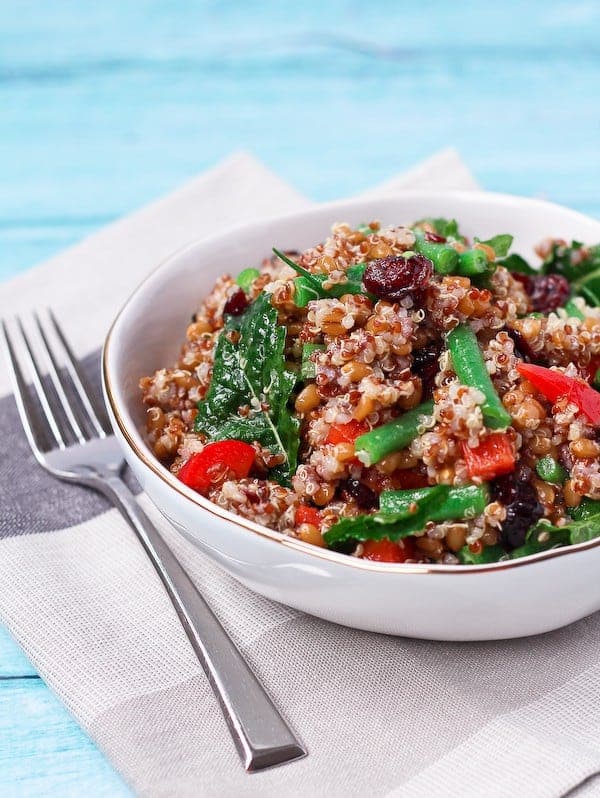 Wheat berry salad with quinoa and green beans in a large white bowl.