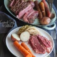 A white plate, containing corned beef slices, 2 carrots, red skinned potato cut in half, and cabbage. Included in the image is oval platter with remaining sliced corned beef, vegetables, with serving utensils. Also in the image is a text overlay that reads " corned beef & cabbage."