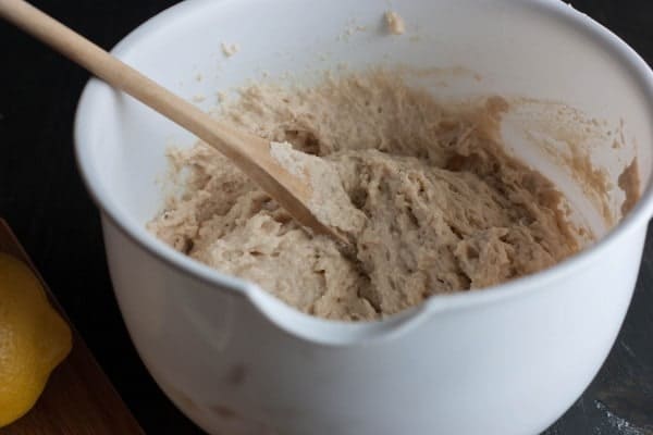 Closeup of mixing bowl containing cake batter and wooden spoon.