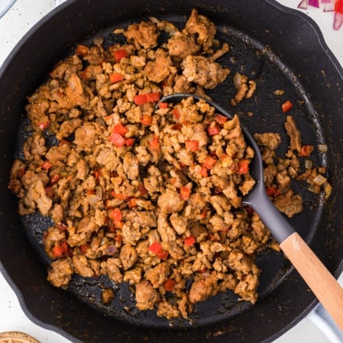 Overhead view of turkey taco meat in a cast iron skillet with a spoon.