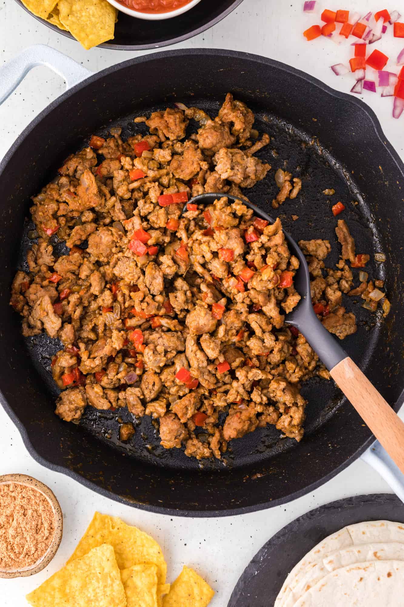 Overhead view of turkey taco meat in a cast iron skillet with a spoon.