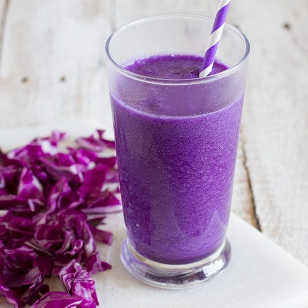 Vibrant Purple smoothie with red cabbage next to it.