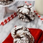 Cookies on folded red napkin on white marble surface.