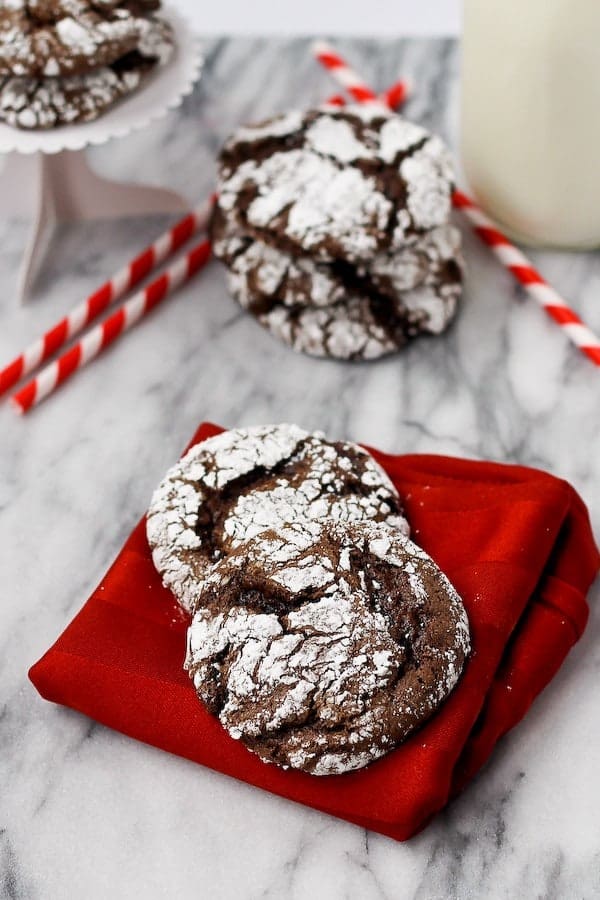 Cookies on red napkin, more cookies in background, and red striped straws.