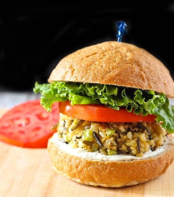 Close up front view of rice burger on bun with tomato and lettuce.